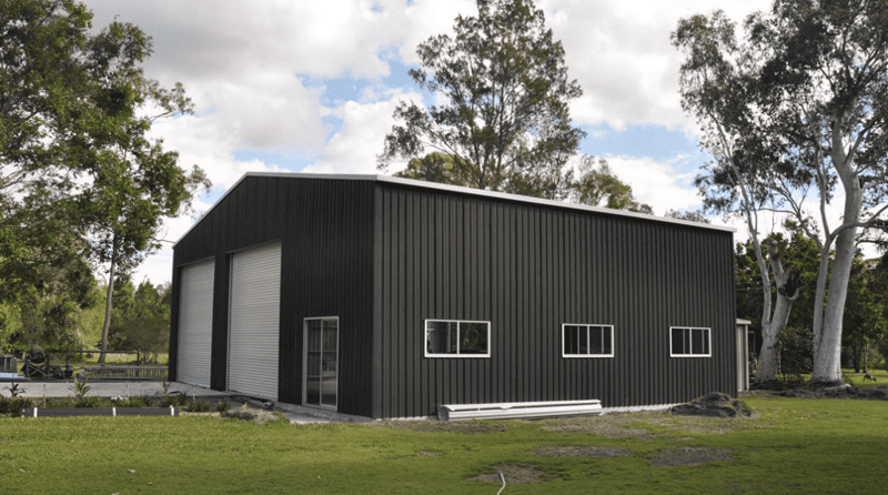 A large metal shed with two roller doors an side windows