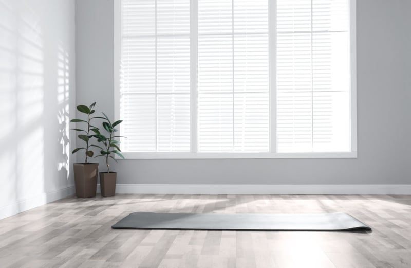 Unrolled Grey Yoga Mat On the Floor In a Room