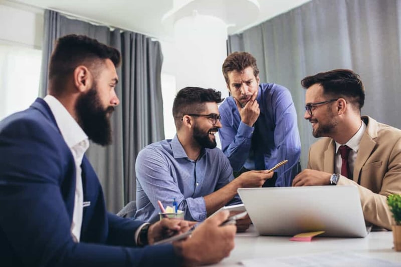 Colleagues at a meeting in a boardroom, sharing ideas about improving customer relationships
